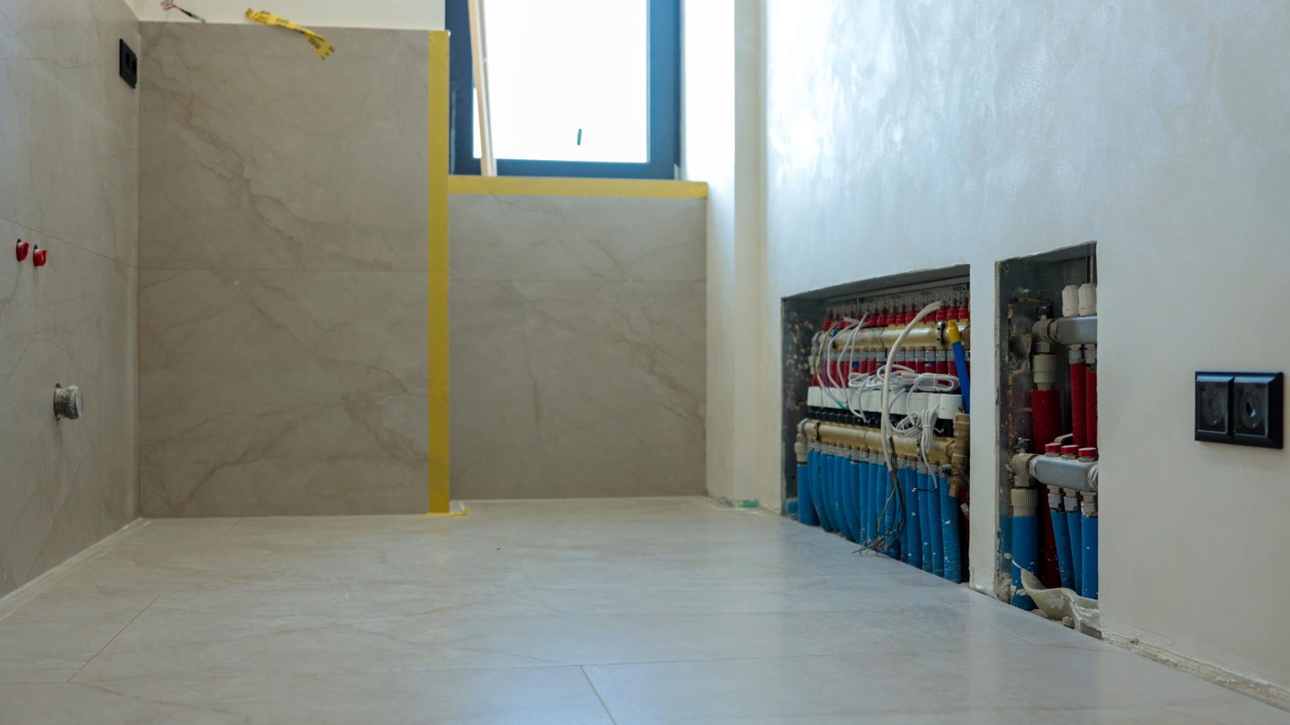 2️⃣ badkamer renovatie kosten – loodgieter installeert leidingen badkamer